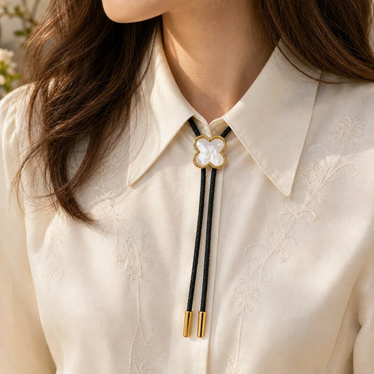 Lucky clover white shell bolo tie worn by a woman with an ivory blouse