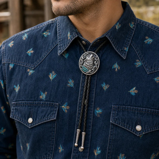 Western wolf bolo tie worn with a dark denim western shirt