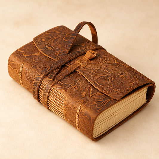 Briar Creek floral-patterned brown cowhide leather journal with a wraparound flap, leather tie and exposed spine stitching.