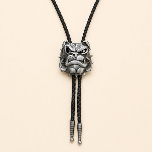 Antique silver English bulldog bolo tie with black braided leather cord on warm ivory background