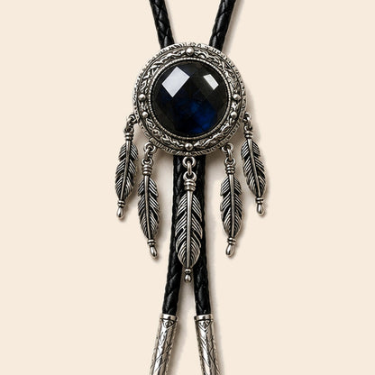 Dreamcatcher labradorite bolo tie with feather accents and black cord on a warm ivory background