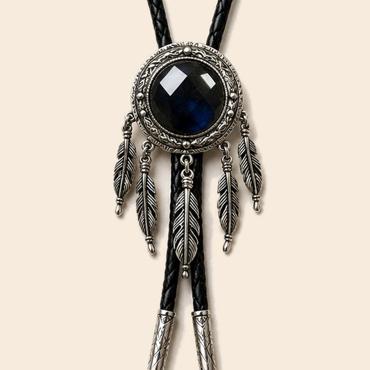Dreamcatcher labradorite bolo tie with feather accents and black cord on a warm ivory background