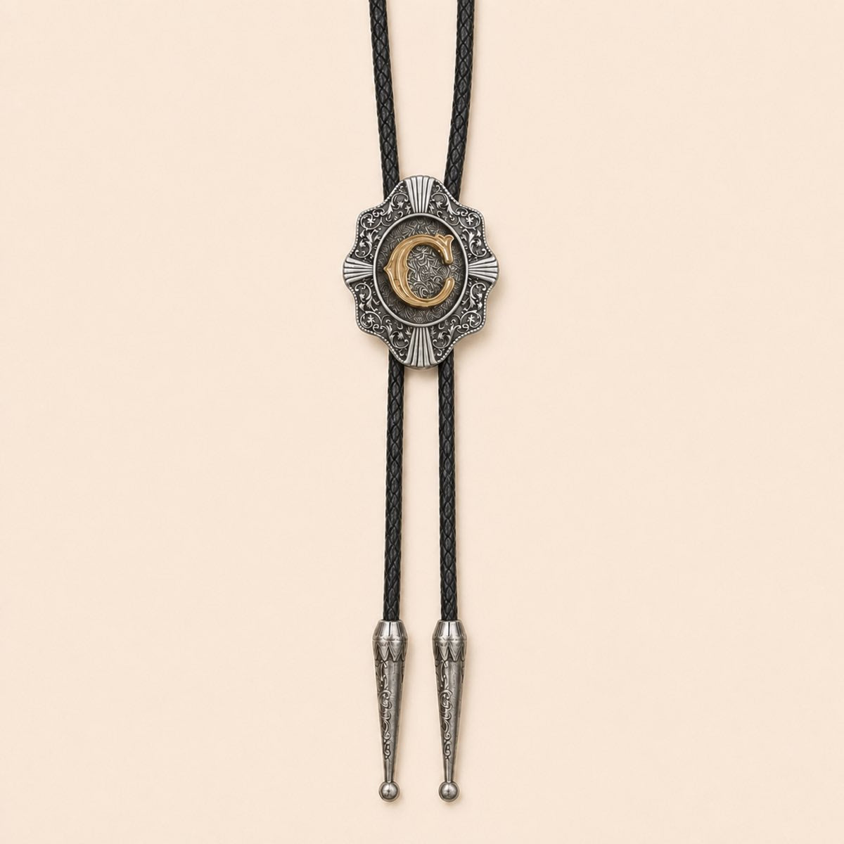 Gold letter C Western bolo tie on a warm ivory background