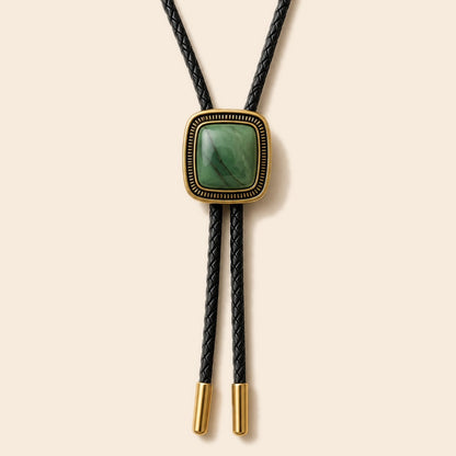 Green jade gold-plated bolo tie on a warm ivory background