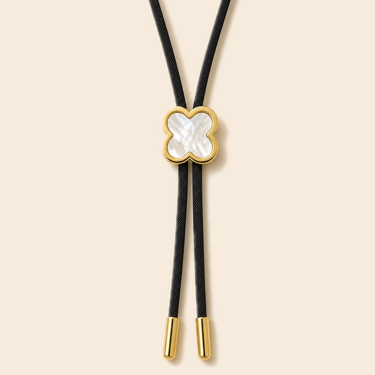 Lucky clover white shell gold-plated bolo tie on a warm ivory background