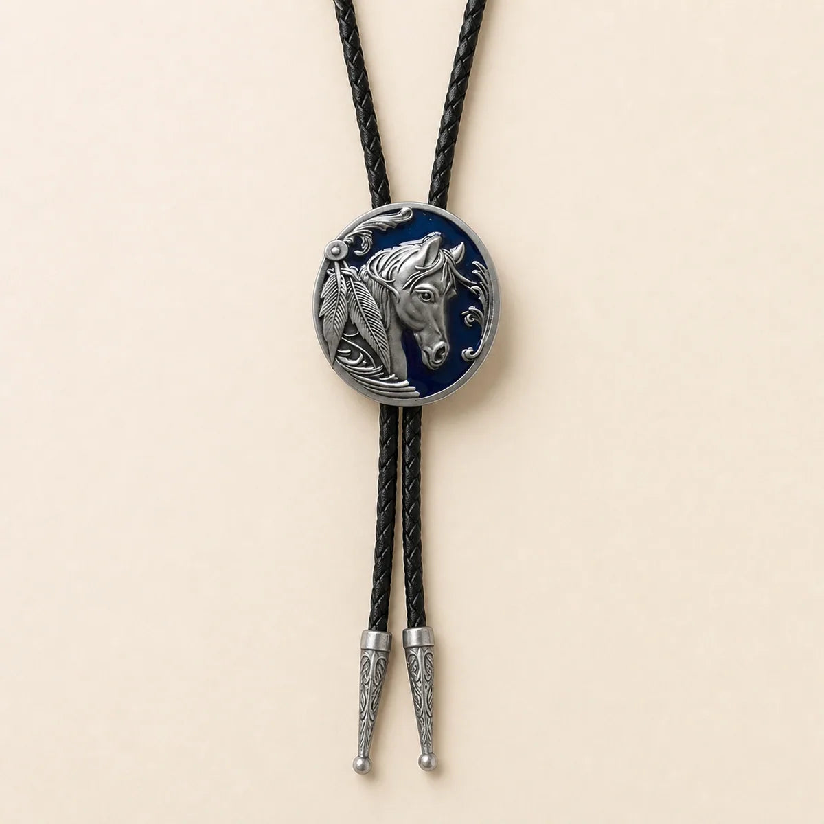 Midnight blue horse head bolo tie with navy enamel medallion on warm ivory background