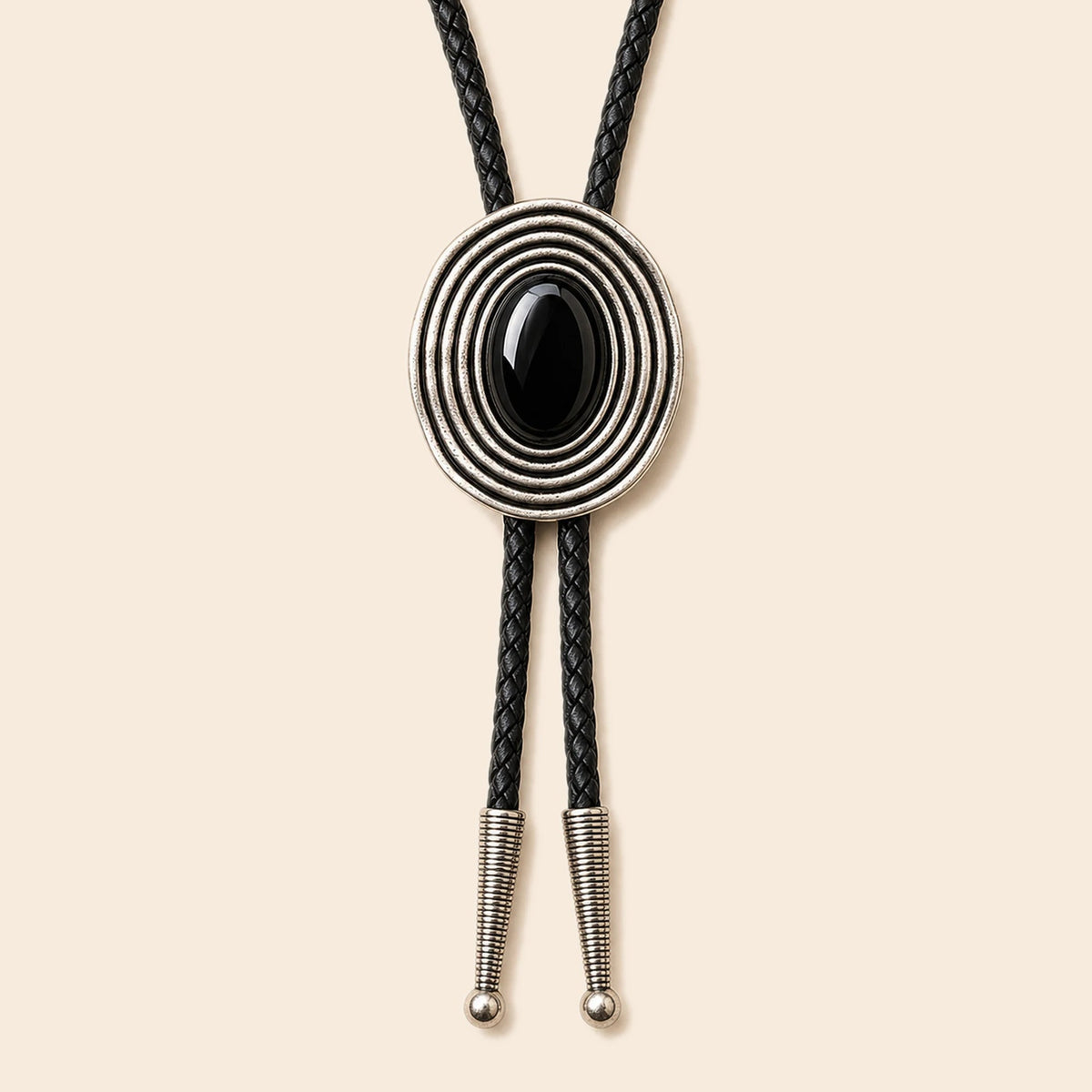 Orbit black obsidian bolo tie with antique silver-tone orbit frame and braided cowhide cord on a warm ivory background