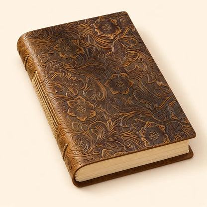 Prairie Bloom brown cowhide leather journal with a floral cover and exposed spine stitching.