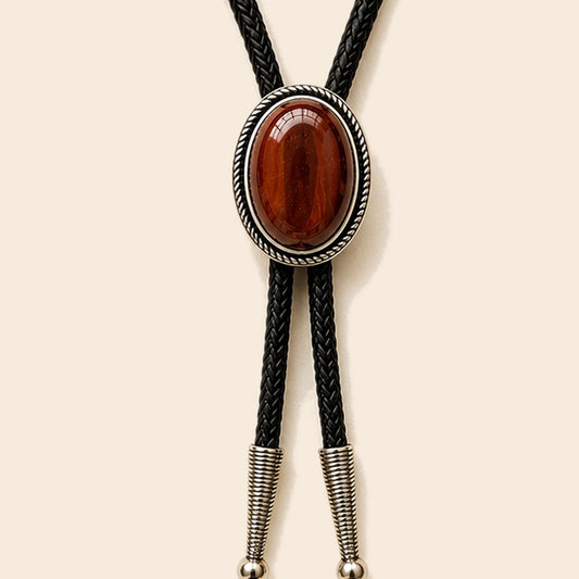 Rust Canyon red tiger eye bolo tie with antique silver-tone frame and leather cord on a warm ivory background