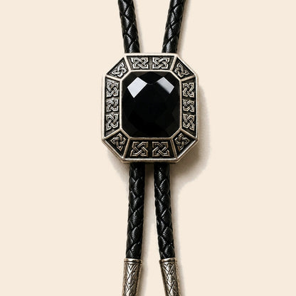 Shadow Ridge black onyx bolo tie with geometric antique silver frame on a warm ivory background