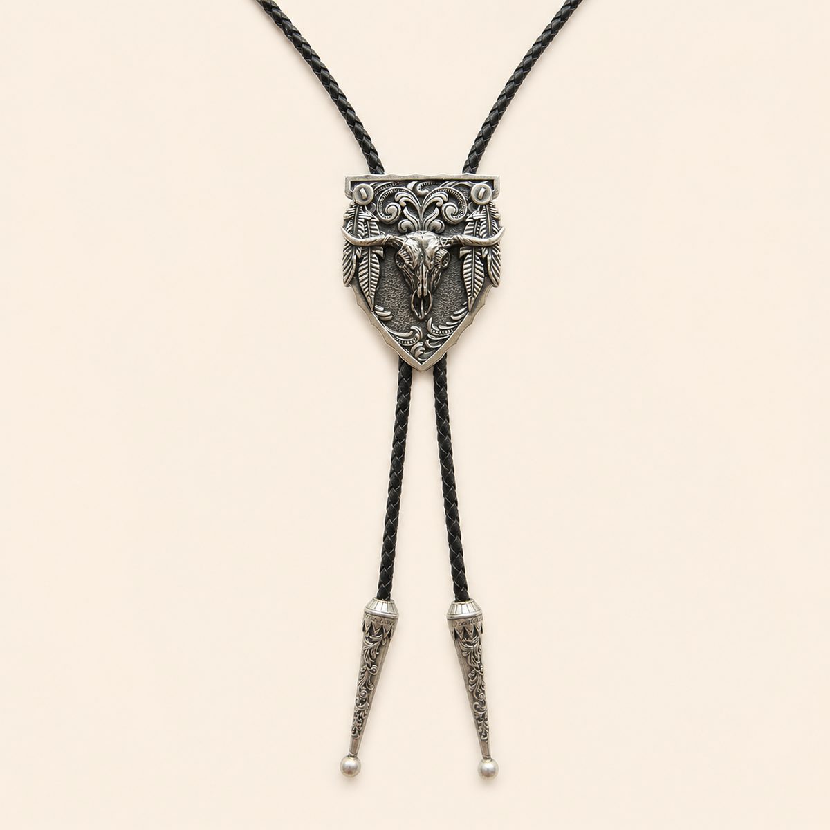 Silver longhorn arrowhead bolo tie with feather details and braided leather cord on warm ivory background