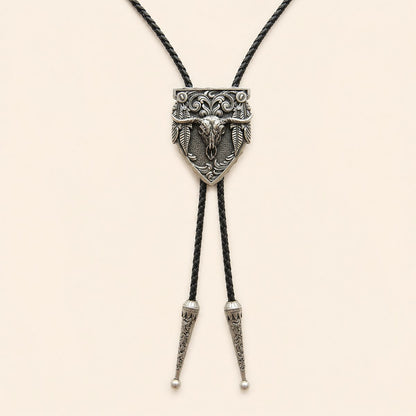 Silver longhorn arrowhead bolo tie with feather details and braided leather cord on warm ivory background