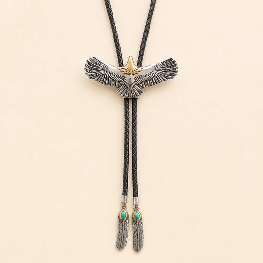 Stainless steel soaring eagle bolo tie with a titanium-gold-tone eagle head and feather tail tips on a warm ivory background
