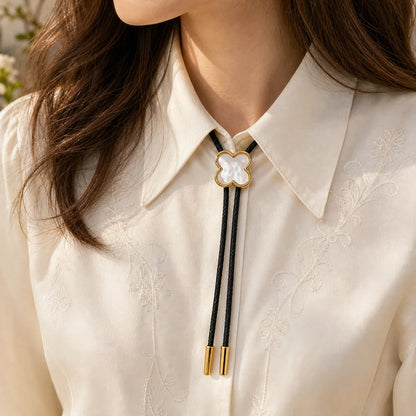 Lucky clover white shell bolo tie worn by a woman with an ivory blouse
