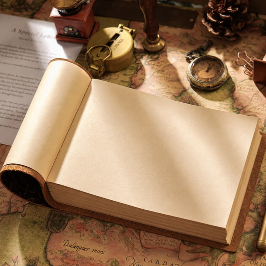 Open landscape leather journal with blank cream pages on a vintage map beside an antique watch.