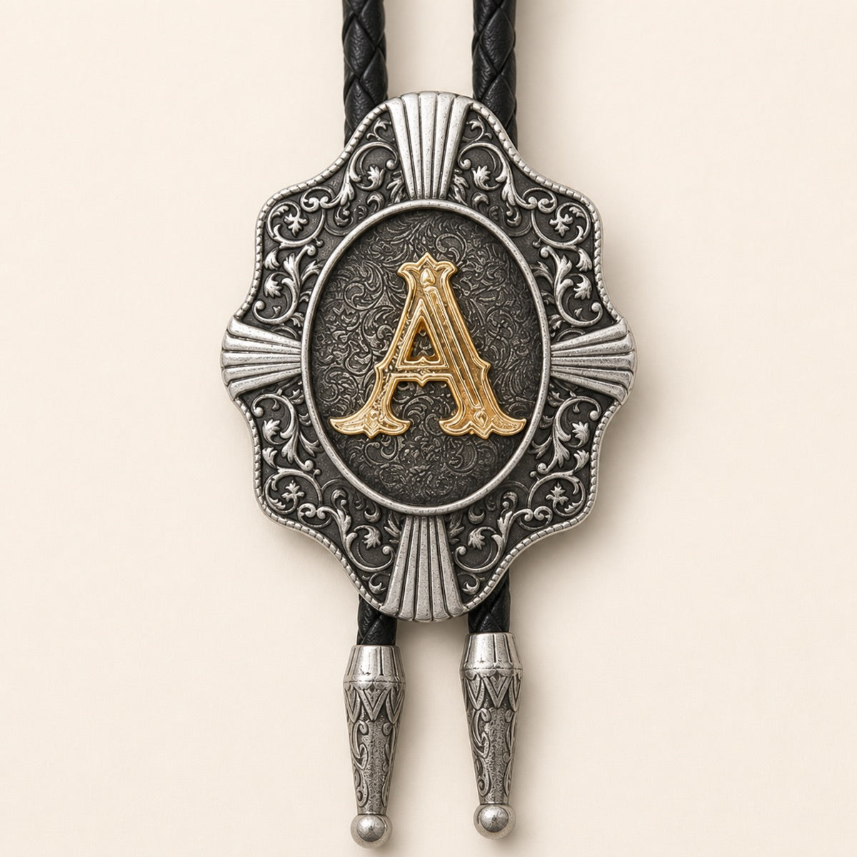 Close-up of raised gold letter A on engraved antique silver Western bolo tie medallion