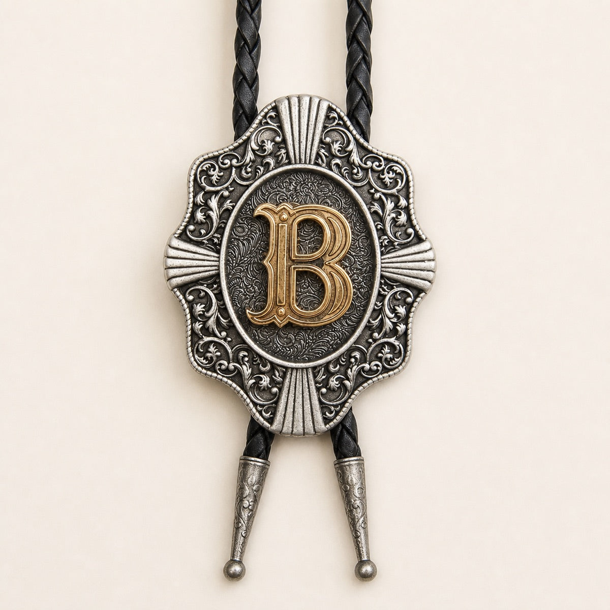 Close-up of raised gold letter B on an antique silver Western bolo tie medallion
