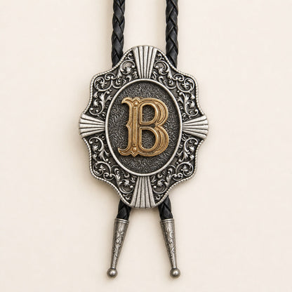Close-up of raised gold letter B on an antique silver Western bolo tie medallion