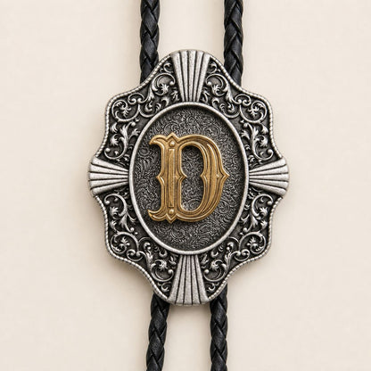 Close-up of gold letter D and engraved antique silver bolo tie craftsmanship