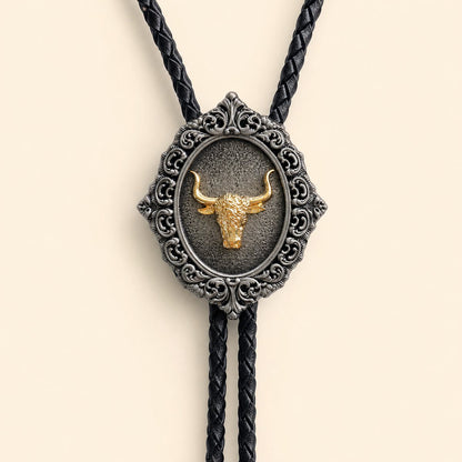 Close-up of the gold longhorn centerpiece in an antique silver scrollwork bolo tie