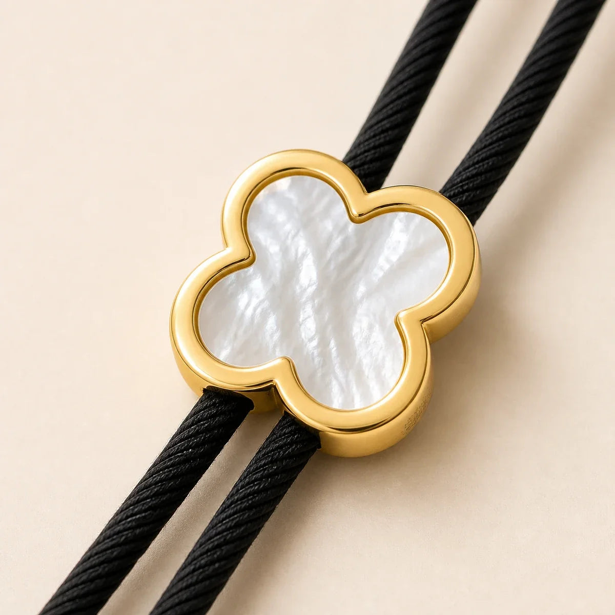 Close-up of gold-plated clover bolo tie with natural white shell inlay