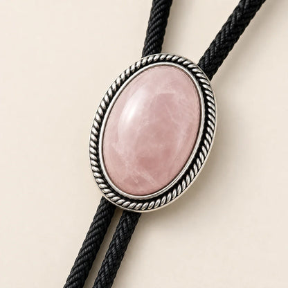 Close-up of rose quartz bolo tie with silver-plated rope border frame