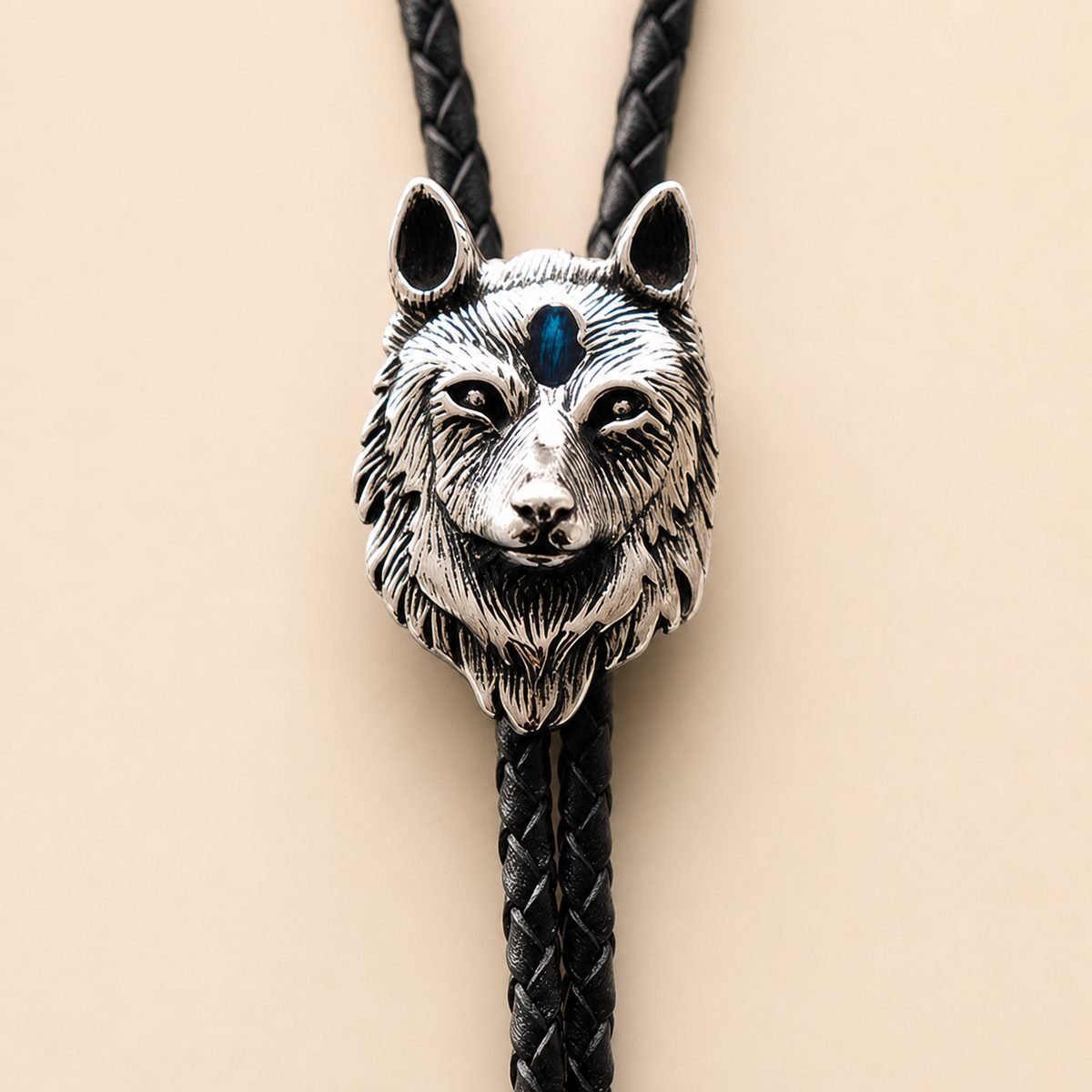 Clean close-up of the polished stainless steel blue inlay wolf head bolo tie