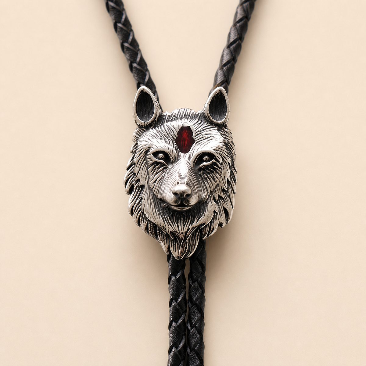 Clean close-up of the polished stainless steel red inlay wolf head bolo tie