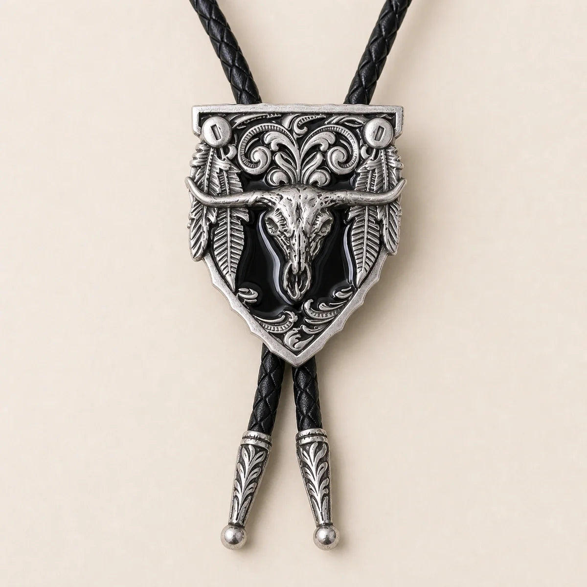 Close-up detail of the black longhorn skull cold enamel bolo tie and silver-tone scrollwork