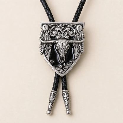 Close-up detail of the black longhorn skull cold enamel bolo tie and silver-tone scrollwork