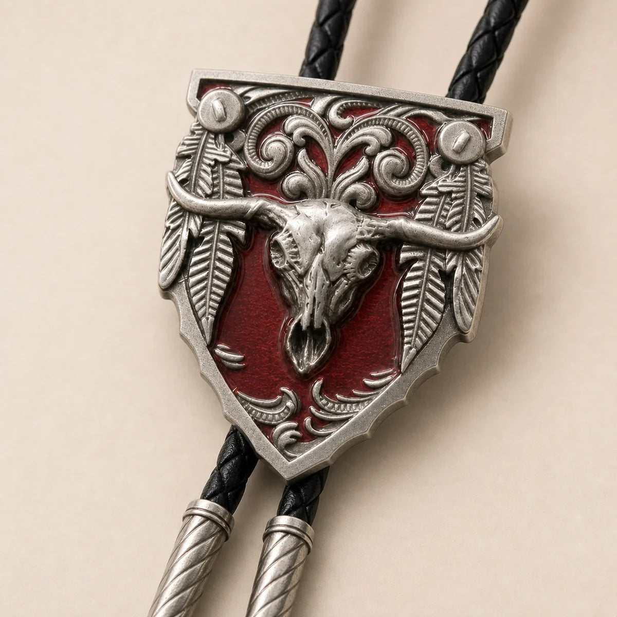 Close-up detail of the red longhorn skull cold enamel bolo tie and silver-tone scrollwork