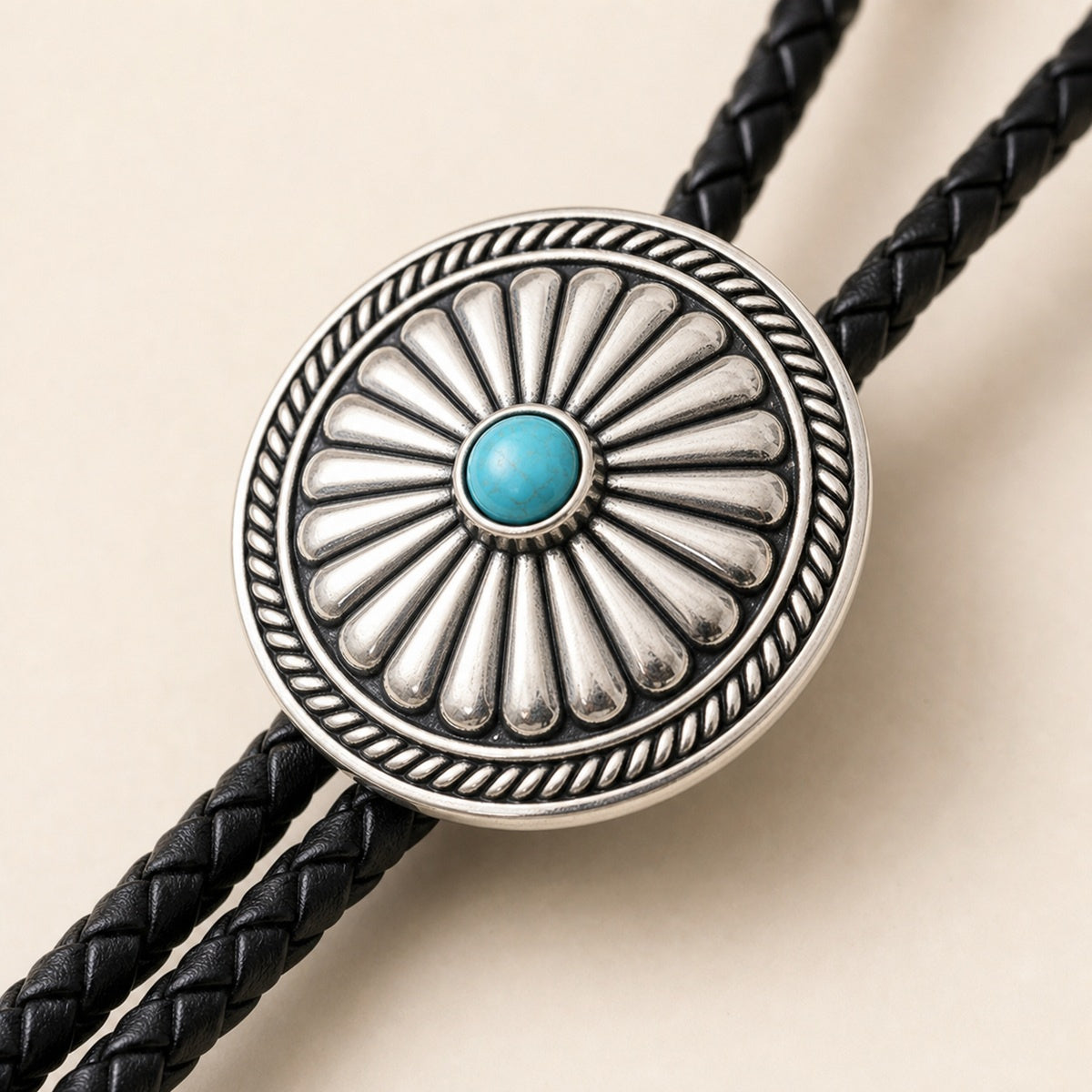 Close-up detail of a turquoise-tone concho bolo tie with antique silver-plated frame