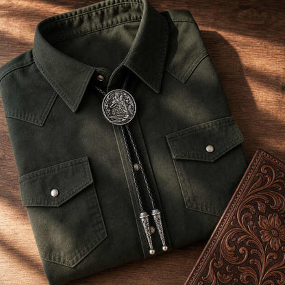 Moonlit Howling Wolf Silver Bolo Tie western flat lay with green shirt and leather