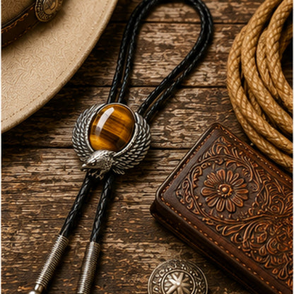 Tiger eye eagle bolo tie flat lay with rustic leather and western accessories
