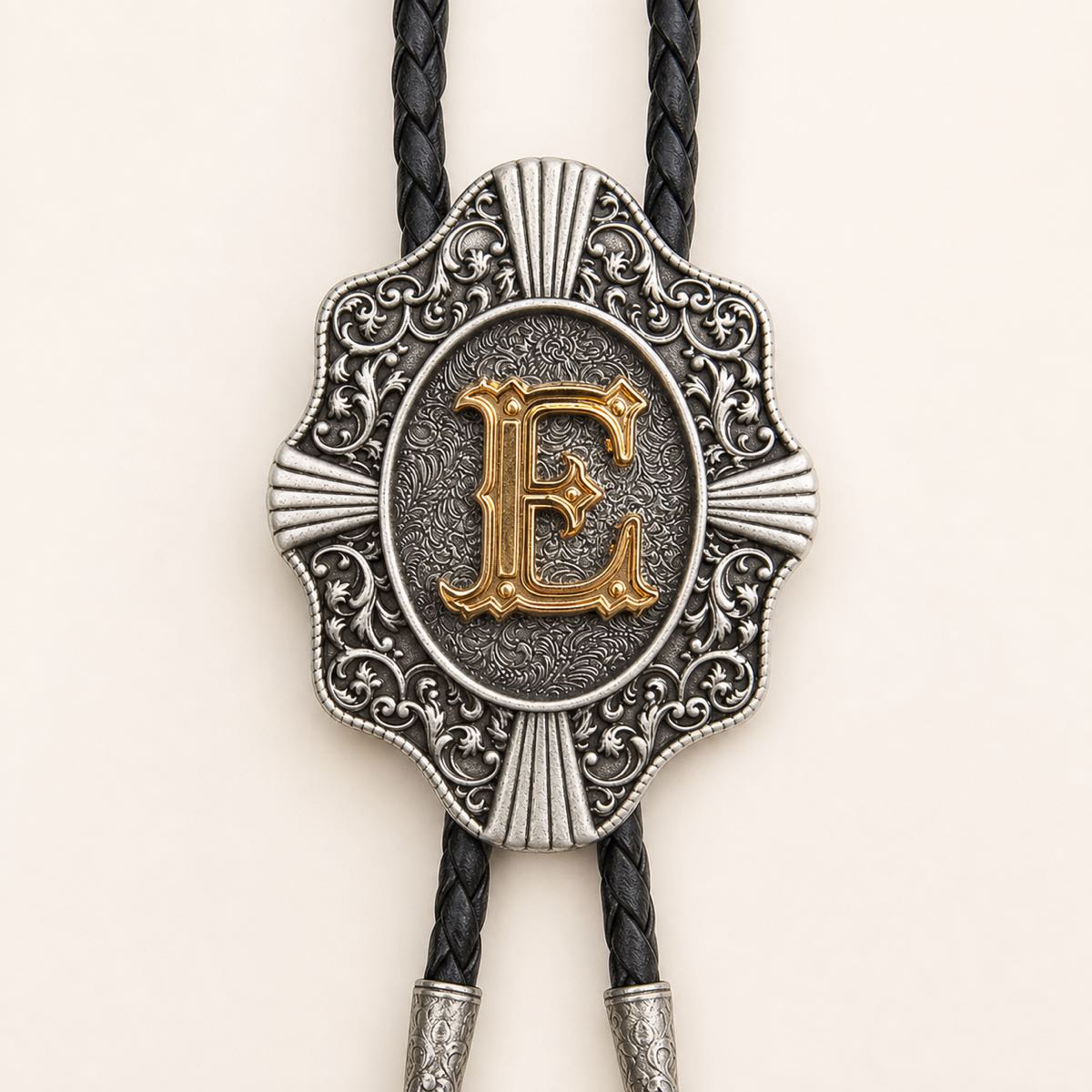 Detailed view of ornate gold letter E bolo tie slide