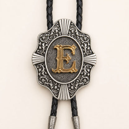 Detailed view of ornate gold letter E bolo tie slide