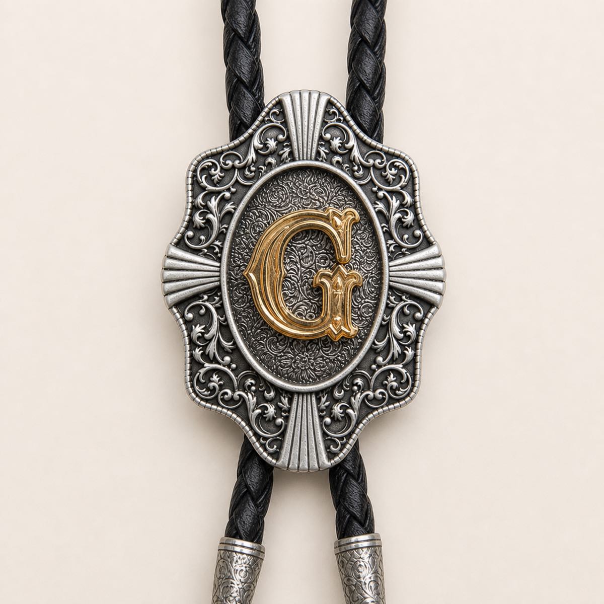 Detailed view of ornate gold letter G bolo tie slide