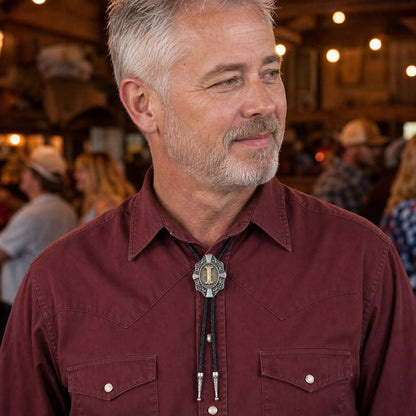Man wearing a gold letter I Western bolo tie