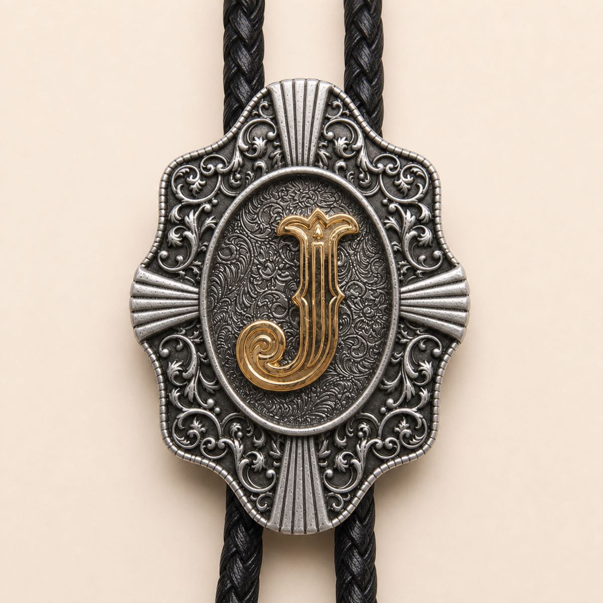 Close-up detail of ornate gold letter J bolo tie slide