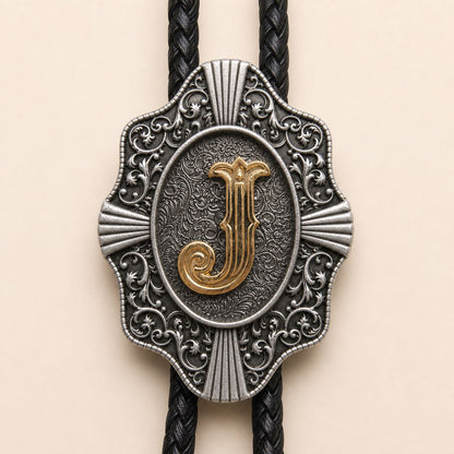 Close-up detail of ornate gold letter J bolo tie slide