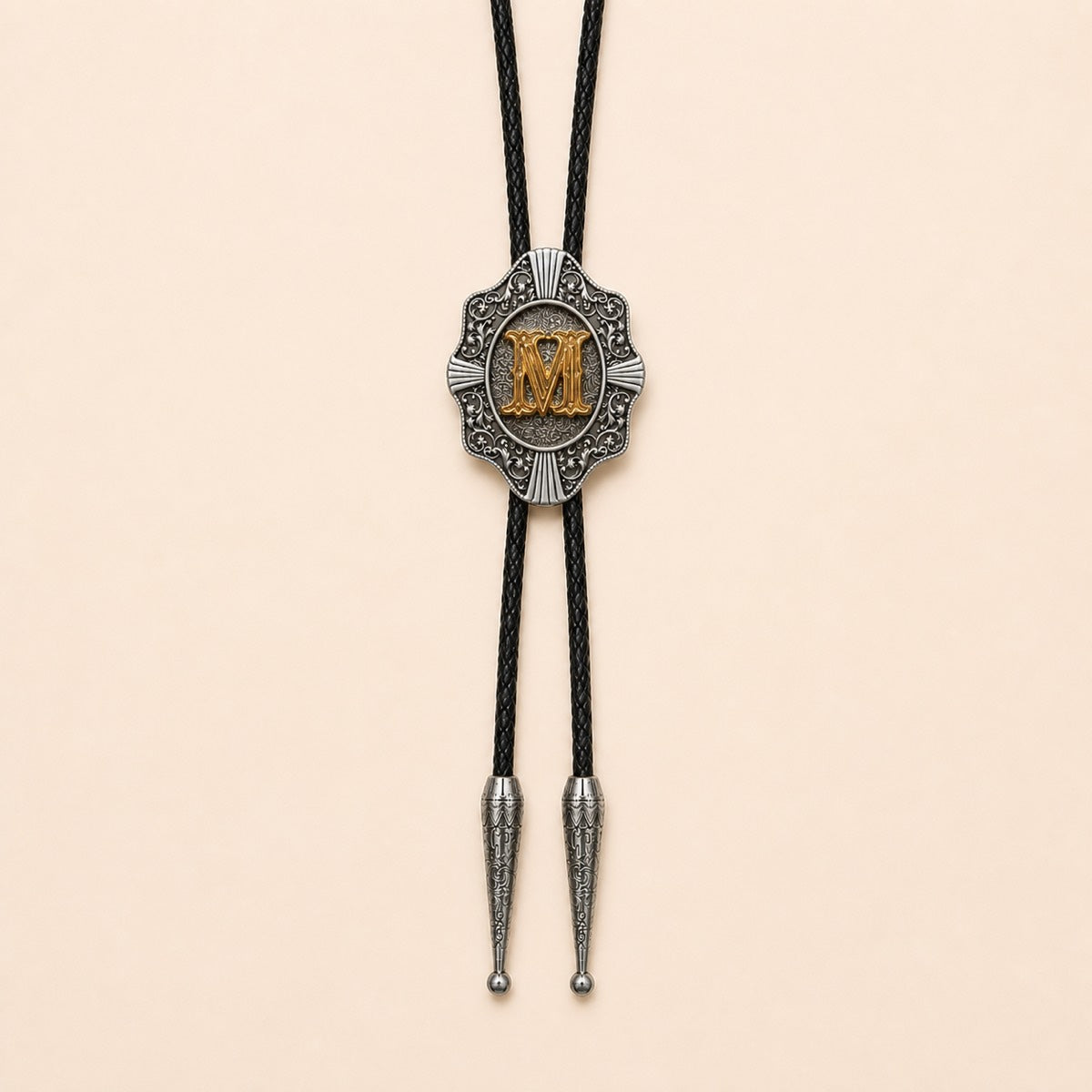 Gold letter M western bolo tie on pale warm ivory background