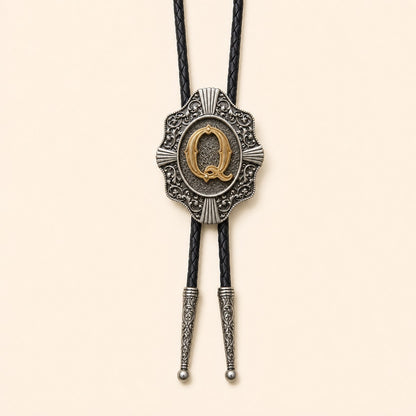 Gold letter Q western bolo tie on pale warm ivory background