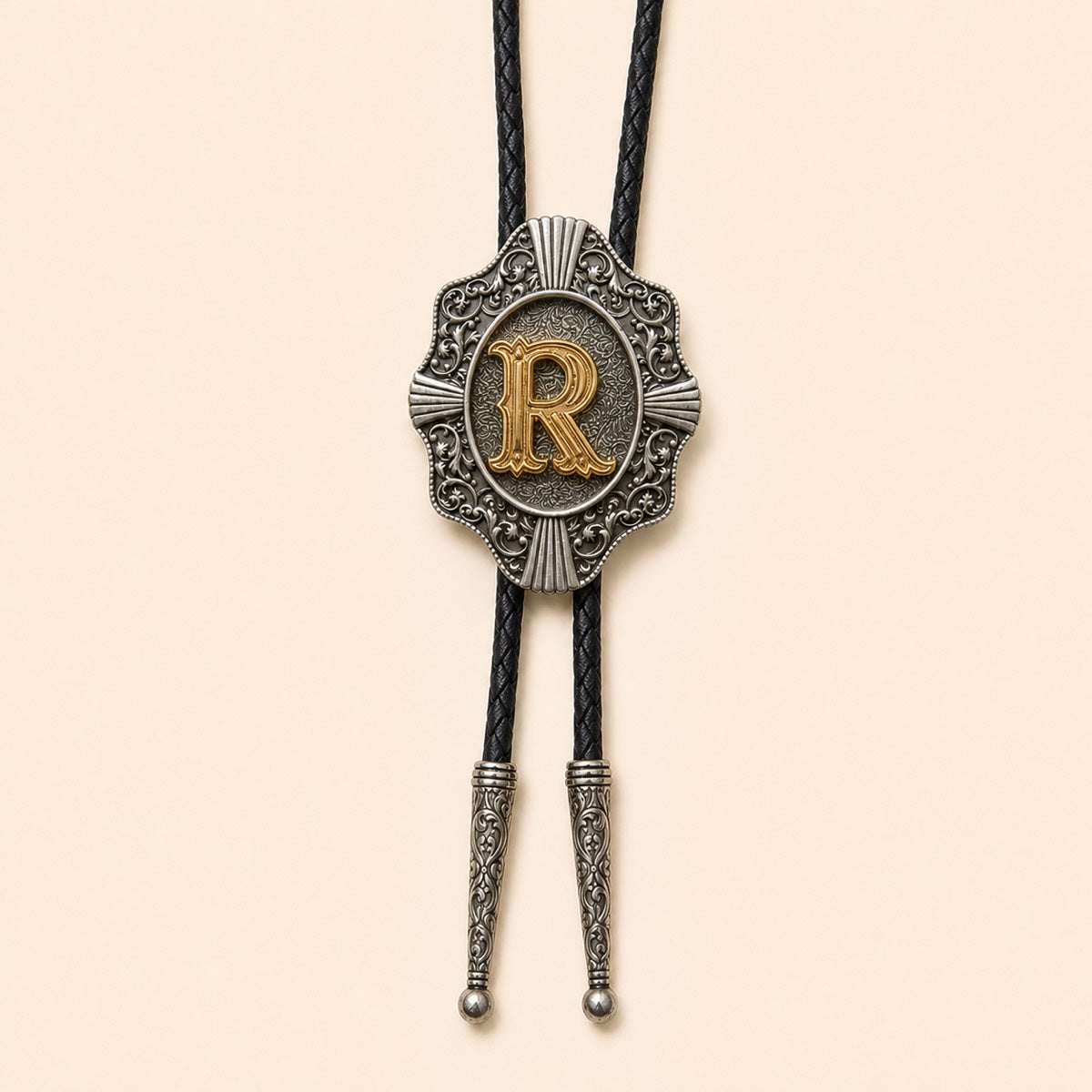 Gold letter R western bolo tie on pale warm ivory background