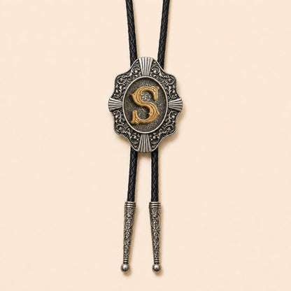 Gold letter S western bolo tie on pale warm ivory background