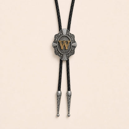 Gold letter W western bolo tie on pale warm ivory background