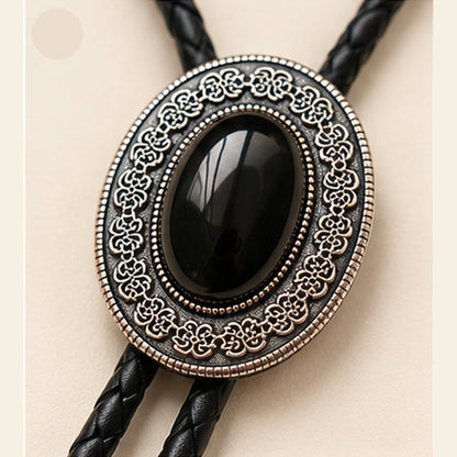 Close-up detail of natural black obsidian stone and antique silver-tone bolo tie frame