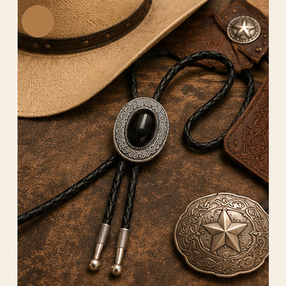 Black obsidian western bolo tie flat lay with rustic leather and western accessories