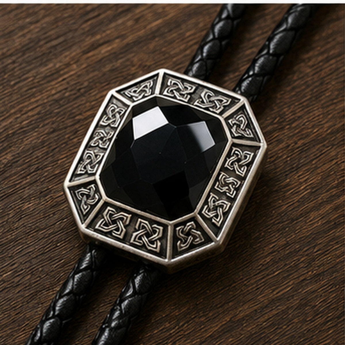 Close-up detail of faceted black onyx stone and antique silver geometric bolo tie frame