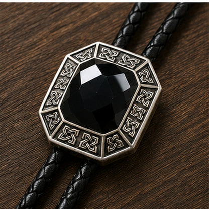 Close-up detail of faceted black onyx stone and antique silver geometric bolo tie frame