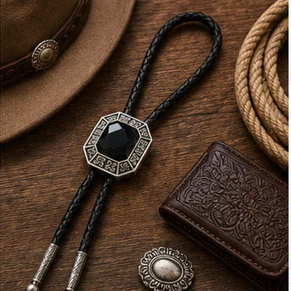 Black onyx western bolo tie flat lay with rustic leather and western accessories